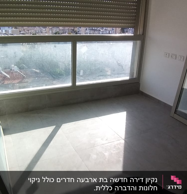 חלון זכוכית מונח על הרצפה ליד חלון גדול